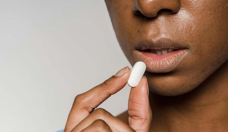 Serious woman about to take a pill