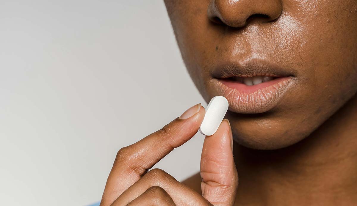 Serious woman about to take a pill